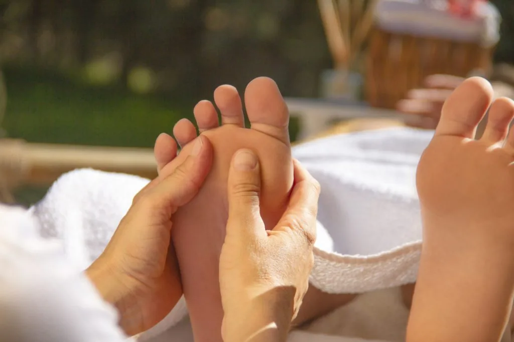 Handen geven een voetreflexmassage